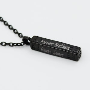 May include: Black necklace with a rectangular pendant engraved with "Forever Brothers Albert James".