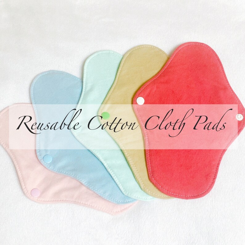 May include: Six reusable cotton cloth pads in various colors, including pink, light blue, mint green, beige, and red. The pads are arranged in a semi-circle with the text "Reusable Cotton Cloth Pads" printed across the center.