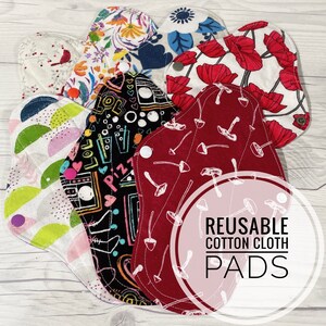 May include: A set of six reusable cotton cloth pads in various patterns. The pads are made of soft, absorbent fabric and are designed to be used as an alternative to disposable sanitary pads. The pads are shown on a white wooden surface with the text "REUSABLE COTTON CLOTH PADS" in a pink circle.