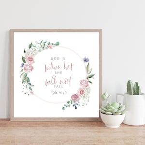 May include: A framed print featuring a watercolour floral wreath and the text "God is within her, she will not fall, Psalm 46:5".