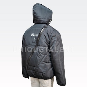 May include: Black hooded puffer jacket with a diagonal zipper and a logo on the back. The jacket has a quilted design and a strap across the shoulder. The text "UNIQUETALENT" is visible on the lower right side of the jacket.