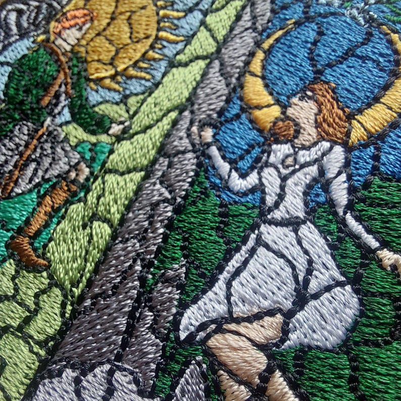 Puede incluir: Obra de arte bordada que representa una escena medieval al estilo vidriera. El dise&ntilde;o incluye una figura con un vestido blanco, una figura en verde y un fondo azul y amarillo. El bordado utiliza varios colores de hilo.