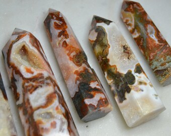 May include: Five agate crystal points with a variety of brown, white and orange patterns. The crystals are polished and have a smooth, glassy finish.