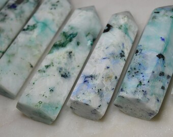 May include: A group of six white, blue, and green crystal points. The points are smooth and polished, with a variety of patterns and textures.