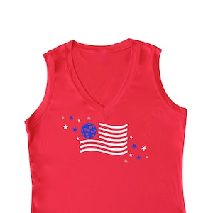 May include: Red sleeveless tank top with a white American flag graphic featuring a blue circle with stars in the center. The graphic is surrounded by white stars.