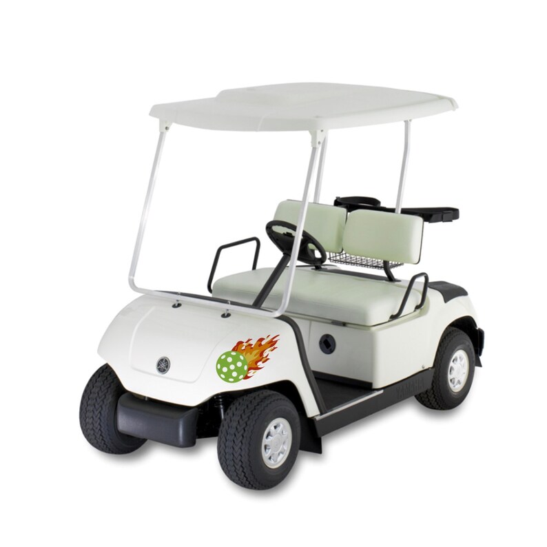 Puede incluir: Carro de golf blanco con una bola verde y blanca de lunares con llamas en el lateral.