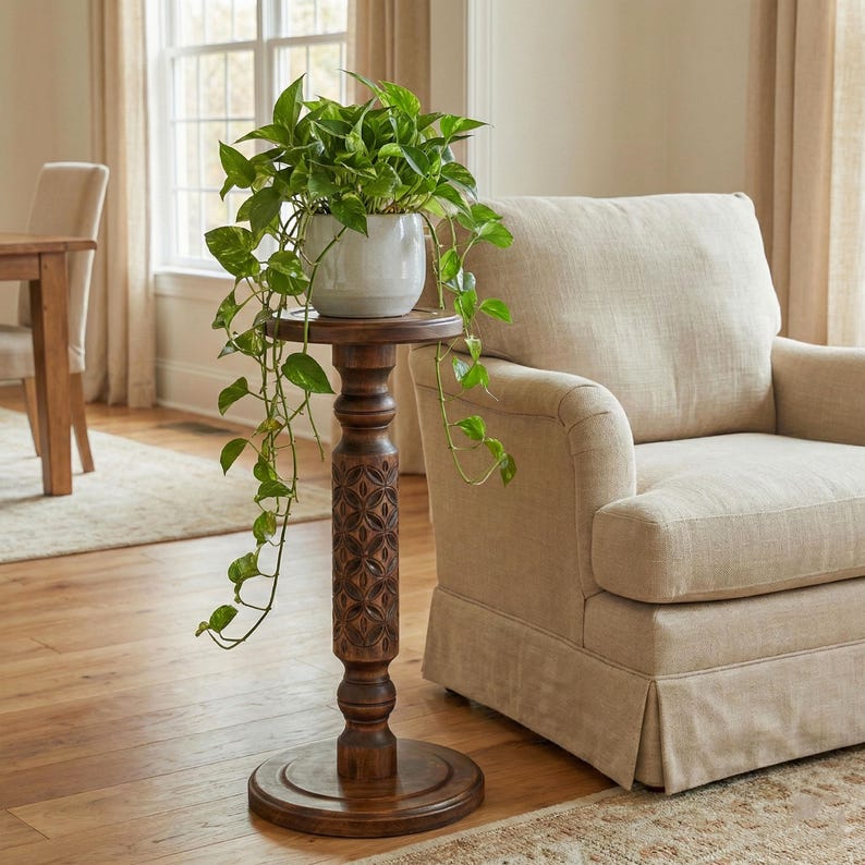 Sturdy wooden floor pedestal holding a large flower pot. Dark brown classic column made of solid oak or ash, designed as a stable display stand for ferns, bonsai, or indoor garden decor.