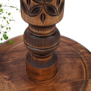 Close-up detail of deep hand-carved geometric motifs on a dark wooden plant column. Solid hardwood texture with a silky oil wax finish, showing the craftsmanship of the turned pillar design.