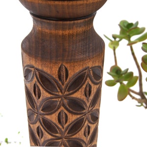 Close-up detail of deep hand-carved geometric motifs on a dark wooden plant column. Solid hardwood texture with a silky oil wax finish, showing the craftsmanship of the turned pillar design.