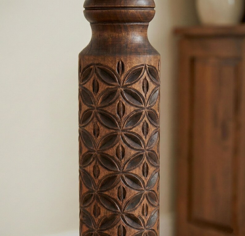 Close-up detail of deep hand-carved geometric motifs on a dark wooden plant column. Solid hardwood texture with a silky oil wax finish, showing the craftsmanship of the turned pillar design.