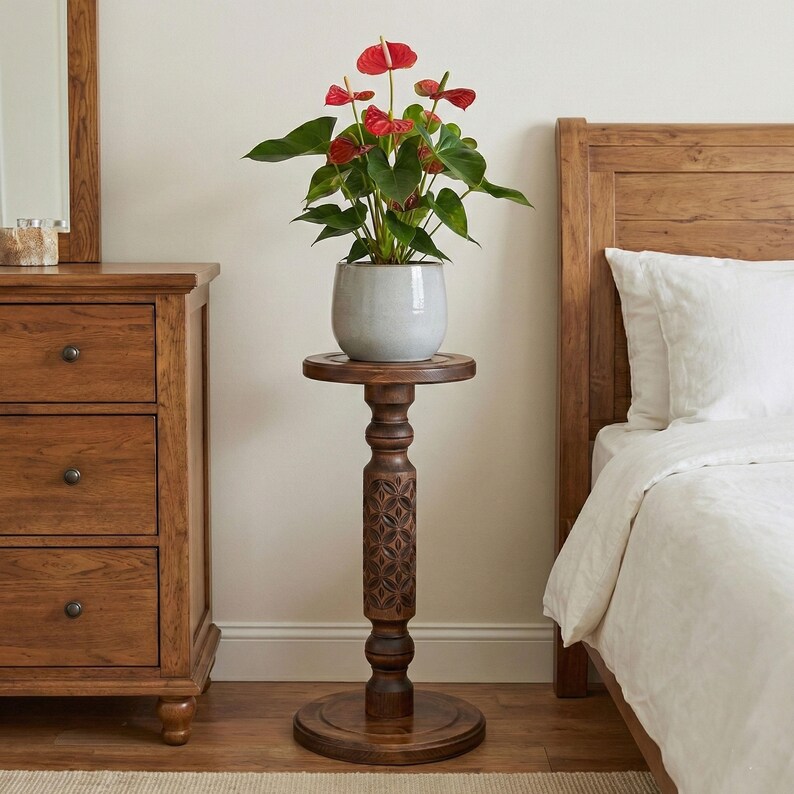 Sturdy wooden floor pedestal holding a large flower pot. Dark brown classic column made of solid oak or ash, designed as a stable display stand for ferns, bonsai, or indoor garden decor.