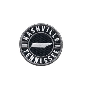 May include: A gray and white embroidered patch with the text "Nashville Tennessee" in a circle around an outline of the state of Tennessee.
