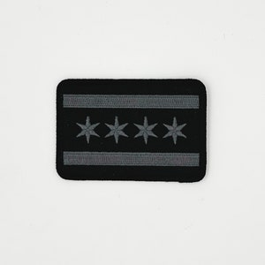 May include: Black embroidered patch with the Chicago flag design. The flag features six white stars on a blue field with two white stripes.