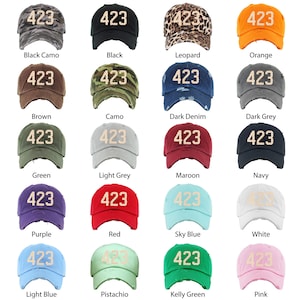 May include: A set of 16 baseball caps in various colors and patterns, each featuring the number "423" embroidered in a cream color on the front.