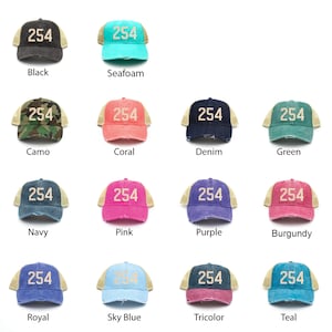 May include: A collection of 14 trucker hats in various colors, each with a beige mesh back and a white embroidered number "254" on the front.