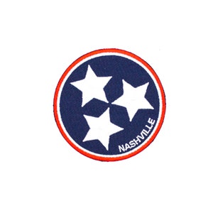 May include: A blue and red circular patch with three white stars and the word "NASHVILLE" in white text.