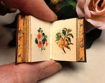 Fleurs is a leather 12th scale miniature book of flowers and fruits, hand bound in stitched rich brown with gold design on cover and spine