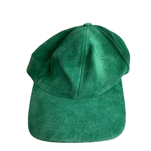 May include: A solid green suede baseball cap.