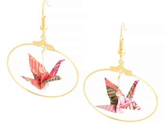 May include: Gold hoop earrings with a pink and green origami crane hanging from each hoop.