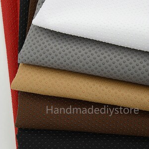 May include: A stack of seven fabric swatches in various colors, including red, black, brown, beige, gray, and white. The fabric has a textured, dotted pattern.