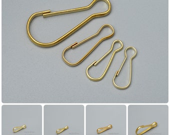 May include: Four gold-colored metal key rings of different sizes. The largest key ring is about 2 inches long, and the smallest is about 1 inch long.