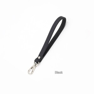 May include: A black leather strap with a silver swivel clasp. The strap is about 18 inches long.