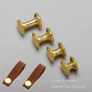 Op de afbeelding: Vier goudkleurige metalen klinknagels, elk met een ronde kop en een cilindrische pen. Twee bruine leren riemen met goudkleurige metalen klinknagels worden getoond als voorbeeld van hoe de klinknagels kunnen worden gebruikt. De tekst "Usage Example" en "Leather Not Included" is onder de riemen gedrukt.