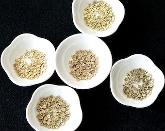 May include: Five white bowls filled with small gold heart-shaped beads.