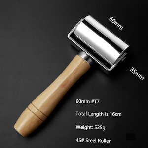 May include: A silver roller with a wooden handle. The roller is 60mm in diameter and 35mm wide. The total length of the roller is 16cm. The roller weighs 535g. The roller is labeled "60mm #T7" and "45# Steel Roller".