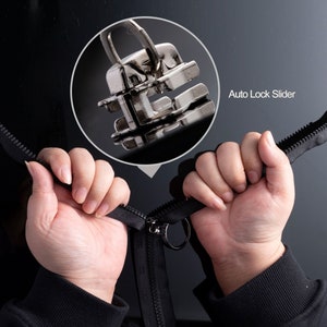 May include: Close-up of a black zipper with a silver metal slider and ring pull. The image includes a magnified view of the auto-lock slider mechanism. The text "Auto Lock Slider" is visible.