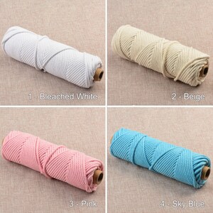 May include: Four spools of cotton rope in different colors: bleached white, beige, pink, and sky blue. The rope is twisted and has a textured surface.