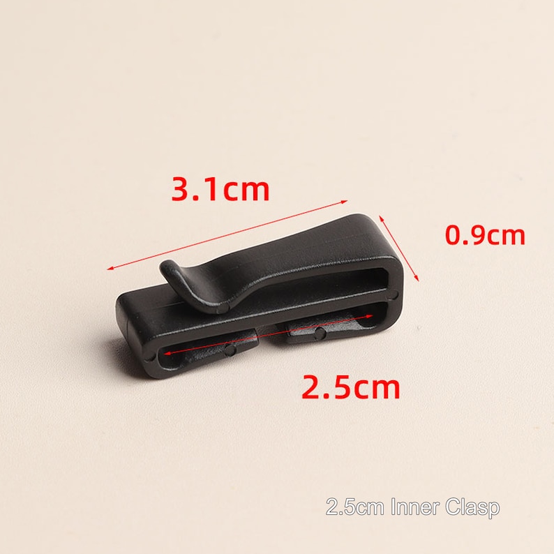 May include: Black plastic clasp with a 2.5cm inner opening. The clasp measures 3.1cm long, 0.9cm wide, and 2.5cm deep.