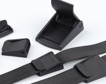 May include: Four black plastic buckles for straps or belts. Two buckles are attached to black webbing straps.