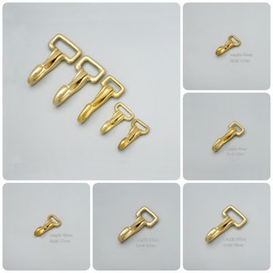 May include: Five gold-toned metal swivel hooks of varying sizes. The hooks are arranged in order of size from largest to smallest. The largest hook is 4.5 inches long and the smallest hook is 2.5 inches long.