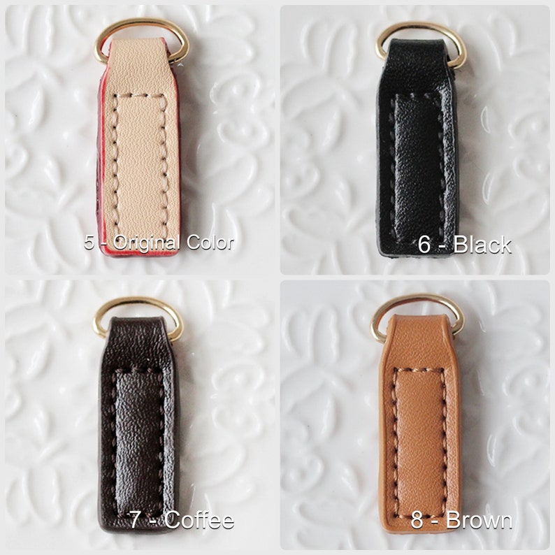 Op de afbeelding: Vier leren sleutelhangers in verschillende kleuren: origineel, zwart, koffie en bruin. Elke sleutelhanger heeft een goudkleurige ring en is gemarkeerd met een nummer en kleurnaam. De sleutelhangers zijn rechthoekig met gestikte randen.