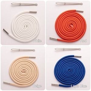 Peut inclure: Quatre bobines de lacets de différentes couleurs : blanc, rouge, beige et bleu lapis. Chaque bobine est enroulée et comprend un embout métallique et un outil de passage de lacet argenté.