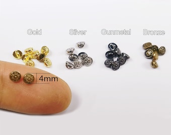 May include: Assortment of 4mm metal buttons in gold, silver, gunmetal, and bronze. Each button has a raised, decorative design.