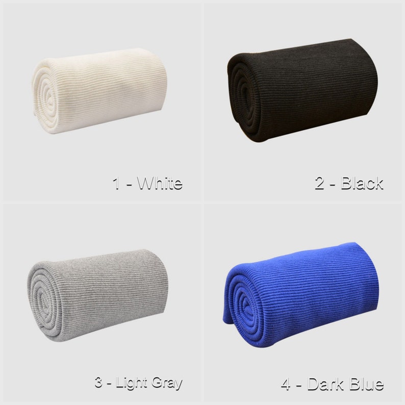 May include: Four rolls of knit fabric in different colors: white, black, light gray, and dark blue. The fabric is rolled up and the ends are visible. The fabric is a ribbed knit.