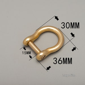 May include: A large, gold-colored shackle with a D-shape. The shackle measures 30mm in height, 36mm in width, and 15mm in thickness. The text "Large Size" is visible. The shackle is made of metal and has a smooth finish.