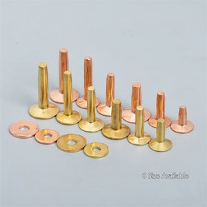 May include: Assortment of brass and copper rivets in various sizes. The rivets have a domed head and a smooth shank. There are six different sizes of rivets, and each size has a corresponding washer.