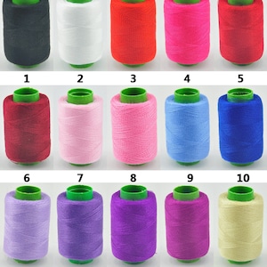 May include: Fifteen spools of thread in various colors, including black, white, red, pink, blue, purple, and beige. The spools are arranged in three rows of five, with each spool labeled with a number from 1 to 15.