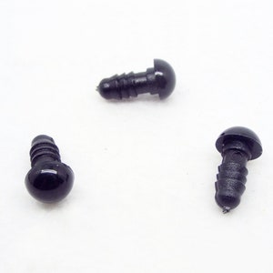May include: Three black plastic safety eyes with a screw-on back. The eyes are round and have a glossy finish.