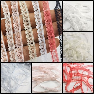 May include: Assortment of delicate lace trim in various colors, including white, cream, pink, red, and black. The lace is approximately 1 inch wide and features a delicate floral pattern.