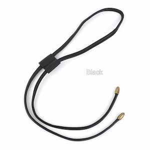May include: Black leather cord necklace with gold-toned metal tips. "Black" is written in white text on a white background.