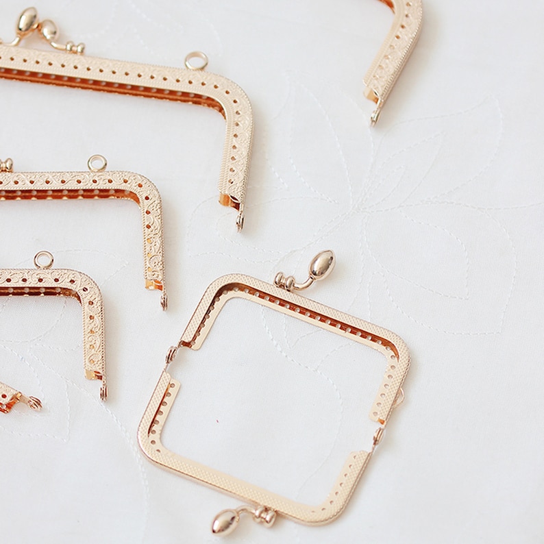 May include: Four gold-toned metal purse frames of different sizes. The frames are open and ready to be used for a DIY project.