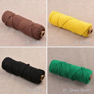 May include: Four spools of cotton rope in different colors: coffee, yellow, black, and grass green. The rope is thick and has a braided texture.