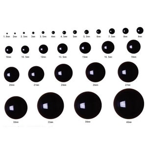 May include: Assortment of black plastic googly eyes in various sizes, ranging from 1.8mm to 40mm.  The eyes are arranged in rows, with the smallest eyes at the top and the largest eyes at the bottom.