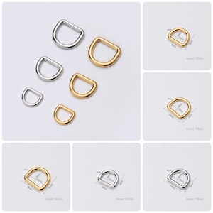 Op de afbeelding: Assortiment van zilveren en gouden D-ringen in verschillende maten. De ringen worden gemeten in inches en millimeters.  Binnen: 1/2 inch, 13 mm; 3/4 inch, 19 mm; 1 inch, 25 mm; 1 1/4 inch, 32 mm.