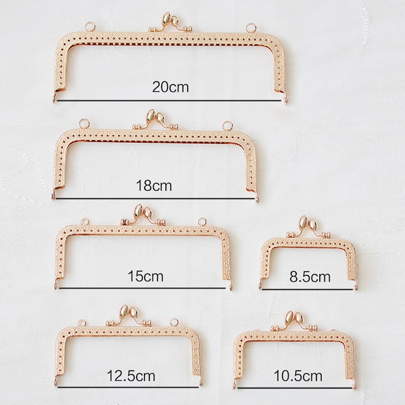 May include: Five gold-toned metal purse frames in different sizes. The frames are 20cm, 18cm, 15cm, 12.5cm, 10.5cm, and 8.5cm in length.
