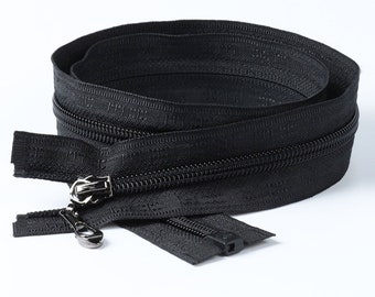 May include: A black zipper, coiled and ready for use, with a silver-toned pull. The close-up shows the teeth and the fabric tape. Ideal for sewing projects, the zipper is set against a white backdrop.